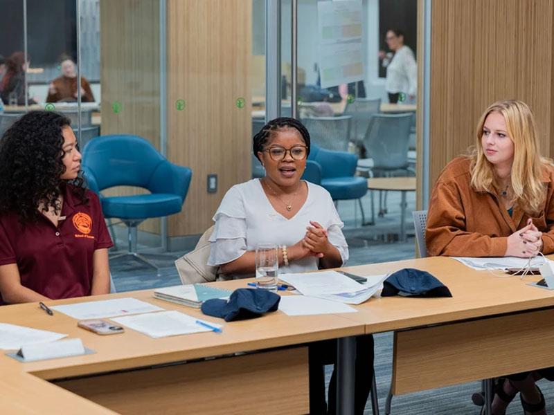 Photo of three students sitting at a table, preparing for meetings during the Seabird Fly-In in Washington, DC.