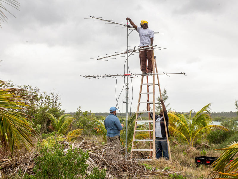 Three people working to build the first Installation of the first Motus Wildlife Tracking tower in Kamalame Cay, Andros, Bahamas.