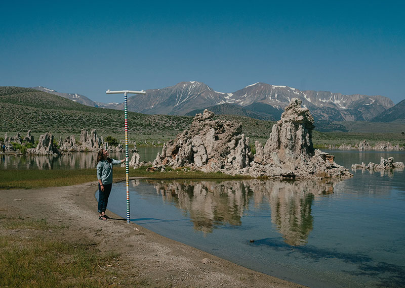 The top of this pole held by Arya Degenhardt, Mono Lake Committee communications director, marks the state-mandated target level that the California lake was supposed to have reached a decade ago.