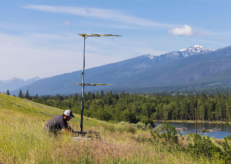 William Blake retrieves data from a Motus station along the Bitterroot River in Montana.