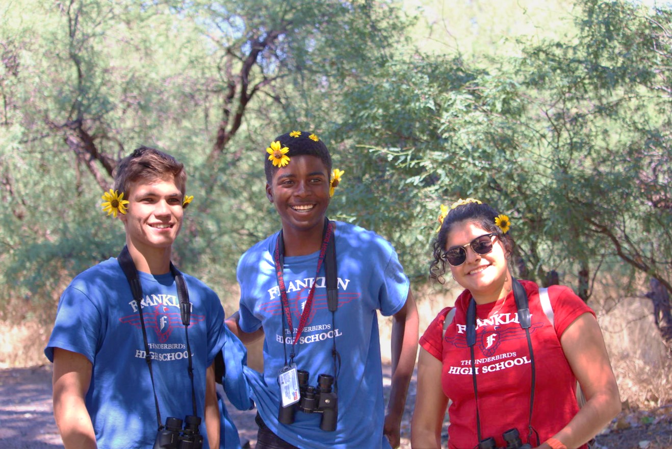 High school students pose with flowers on a River Pathways field trip to Agua Fria National Monument.