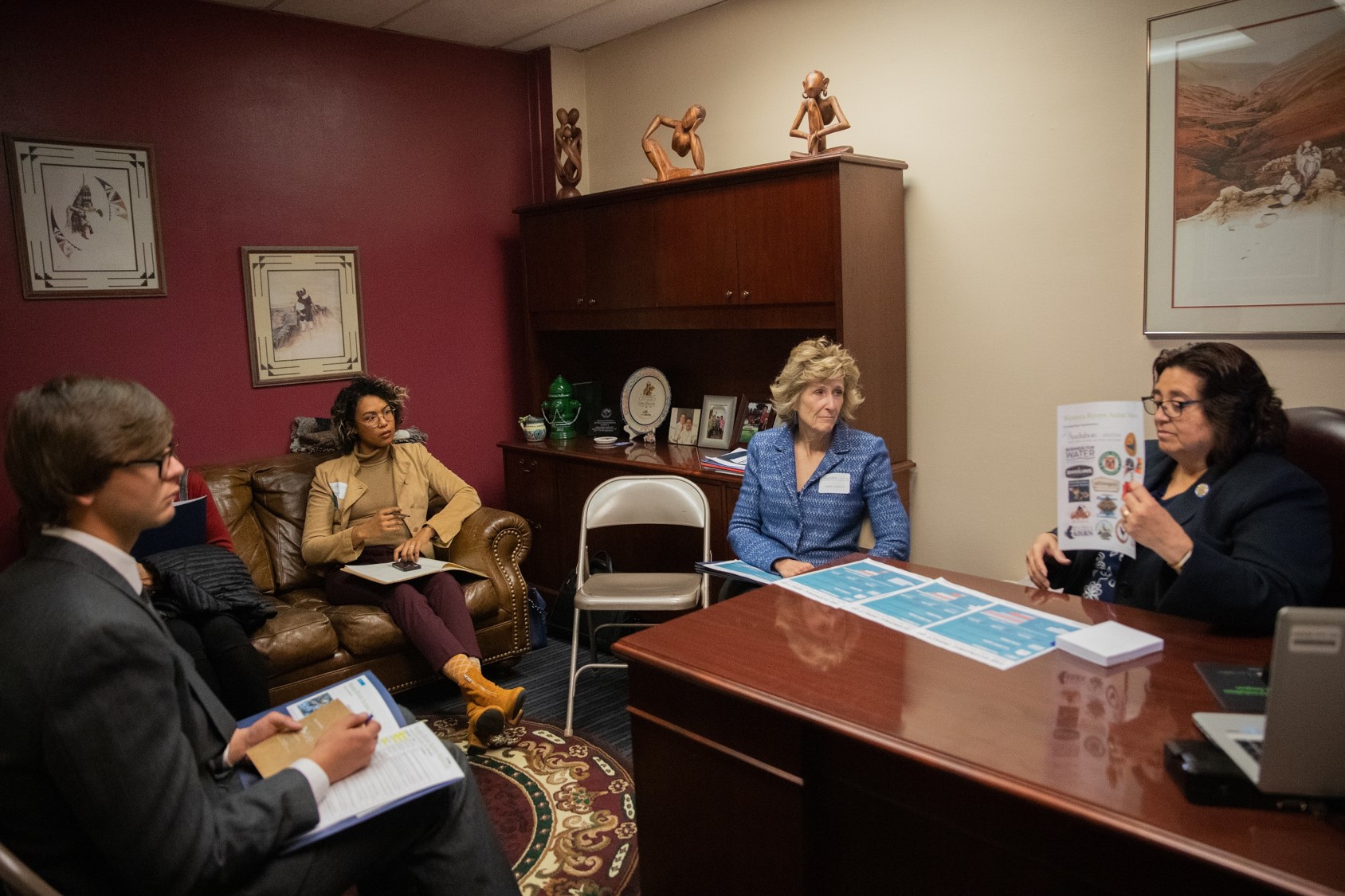 Dan Hite, Xulia Suero, and Karen Gaylord meet with Rep. Rosanna Gabaldón in her office as she reviews information on the Western Rivers Action Network.