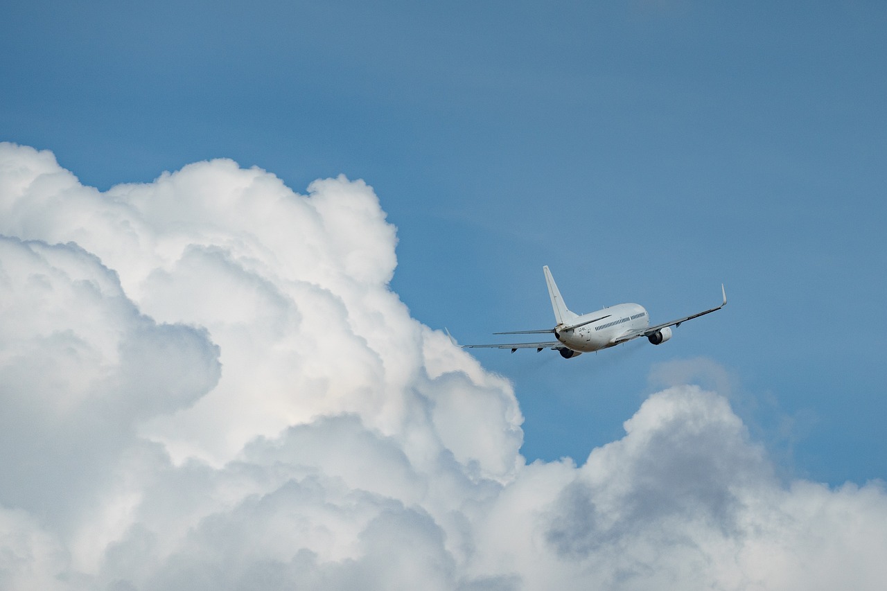 An airplane flying in blue sky over white clouds