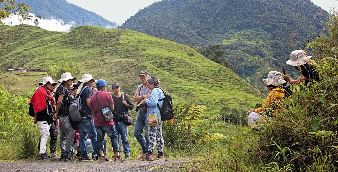 Photo of people standing in front of a mountain-scape in San Antonio del Chamí, Colombia.