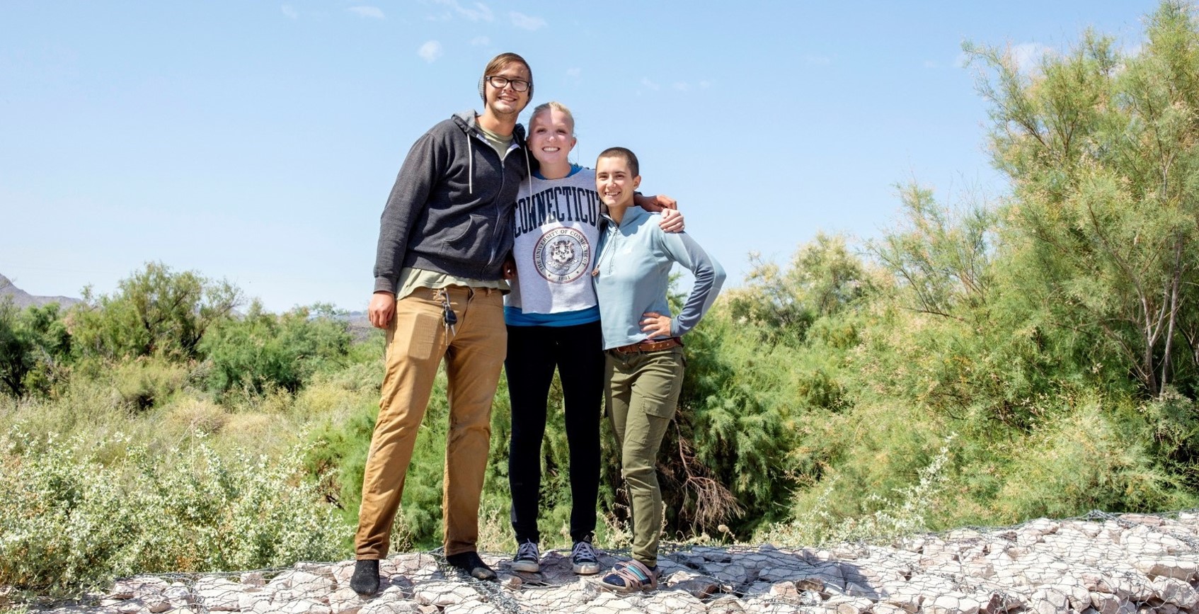 The three Mackenzie Fellows stand together smiling.