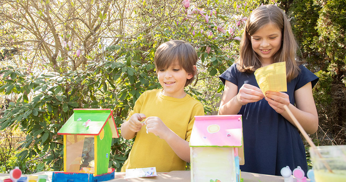 Two kids crafting bird houses.