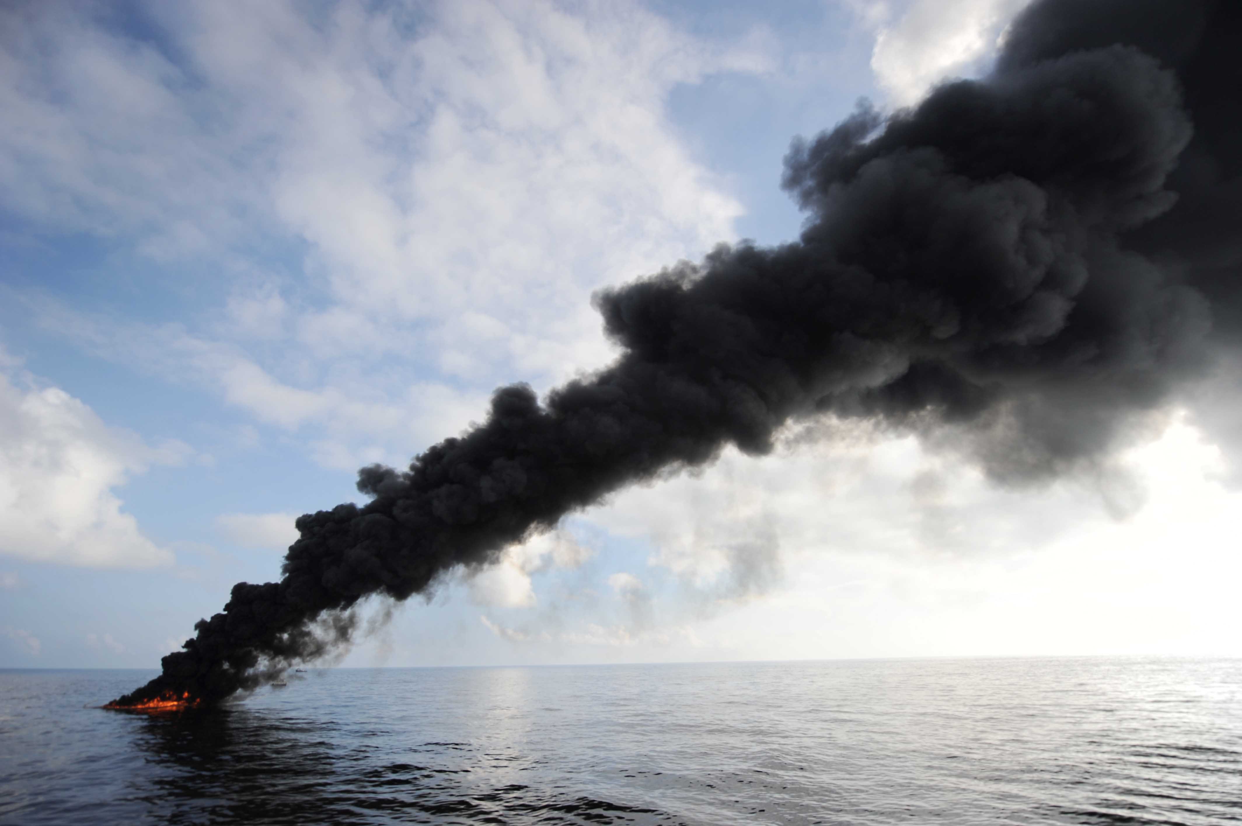 Dark clouds of smoke and fire emerge as oil burns during a controlled fire in the Gulf of Mexico.