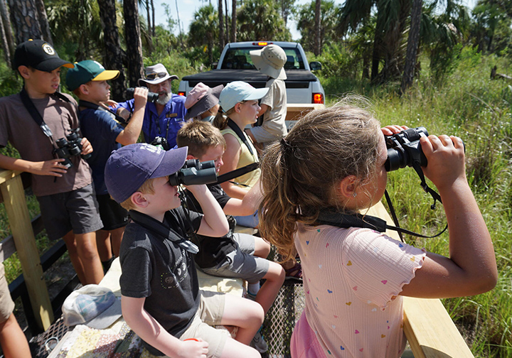 Summer campers looking through binoculars.