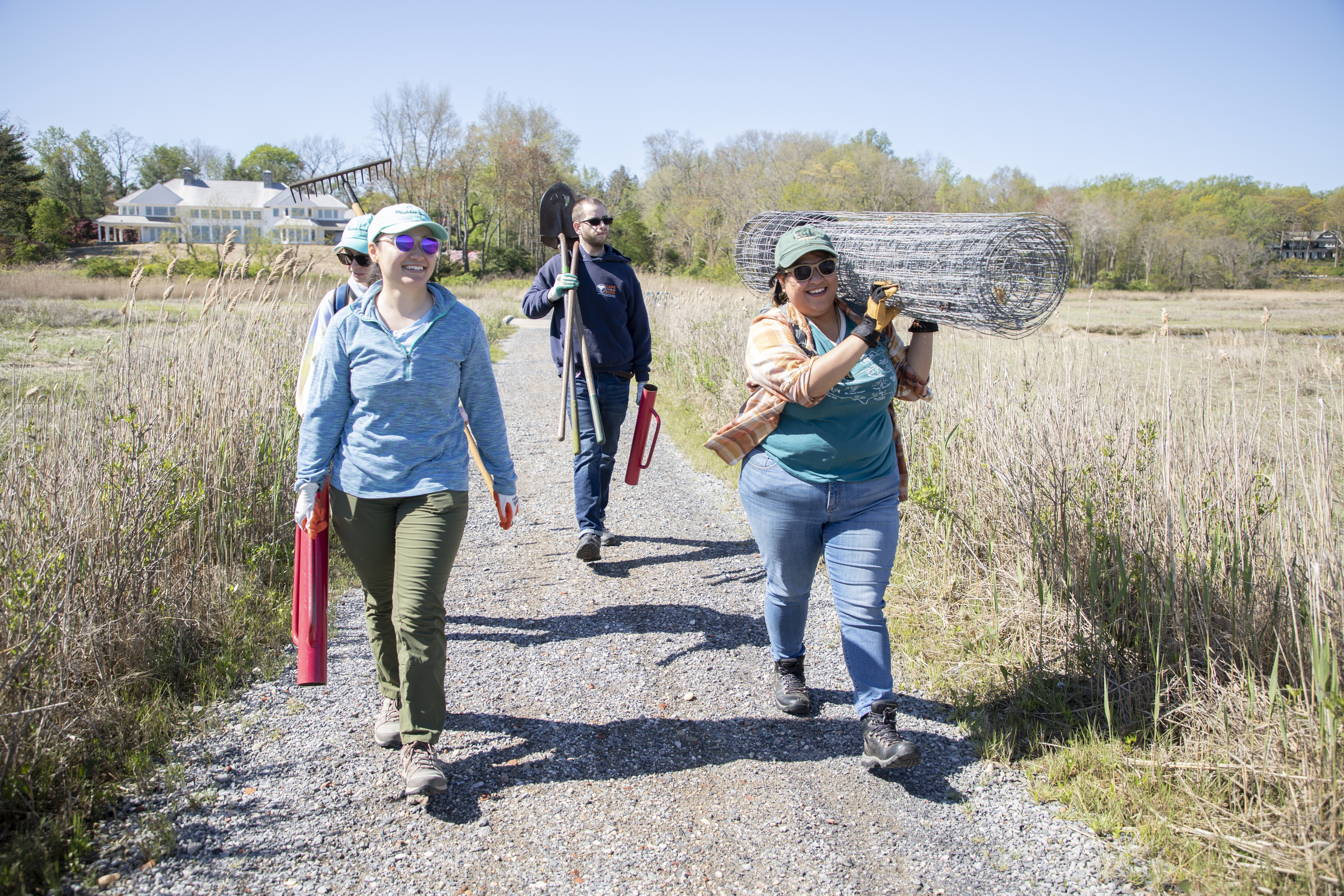 Shelby Casas, far right, Coastal Program Associate for Audubon Connecticut and Audubon New York, works with seasonal Shorebird Field Technicians to enclose a Piping Plover nest along a private beach property in Sands Point, New York, May 10, 2022. The enclosure, which was rejected by the nesting pair and had to be removed, is meant to protect the eggs from predators, human interaction, and other detrimental hazards to the eggs. Photo: Luke Franke/Audubon