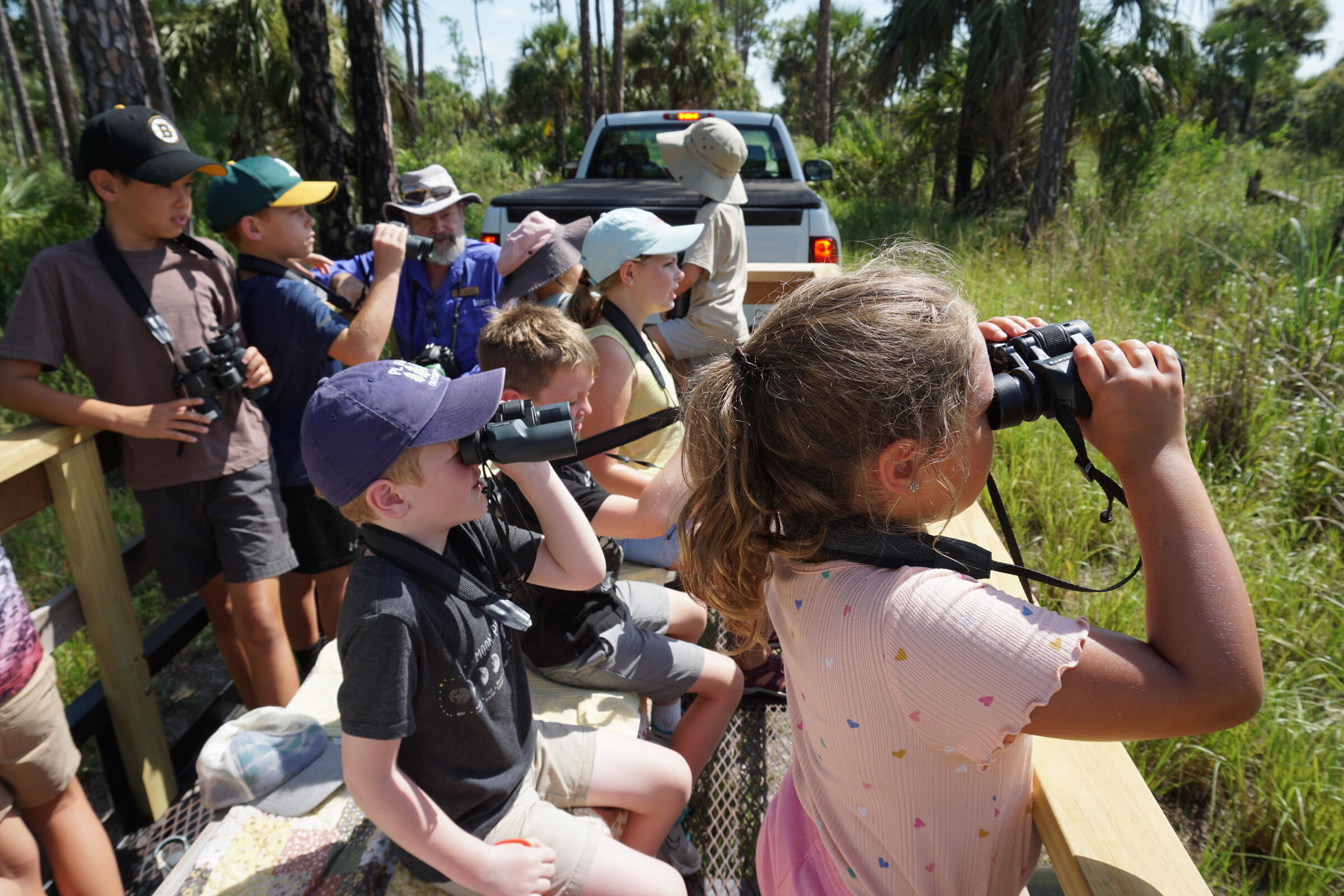 Students looking through binoculars at nature.