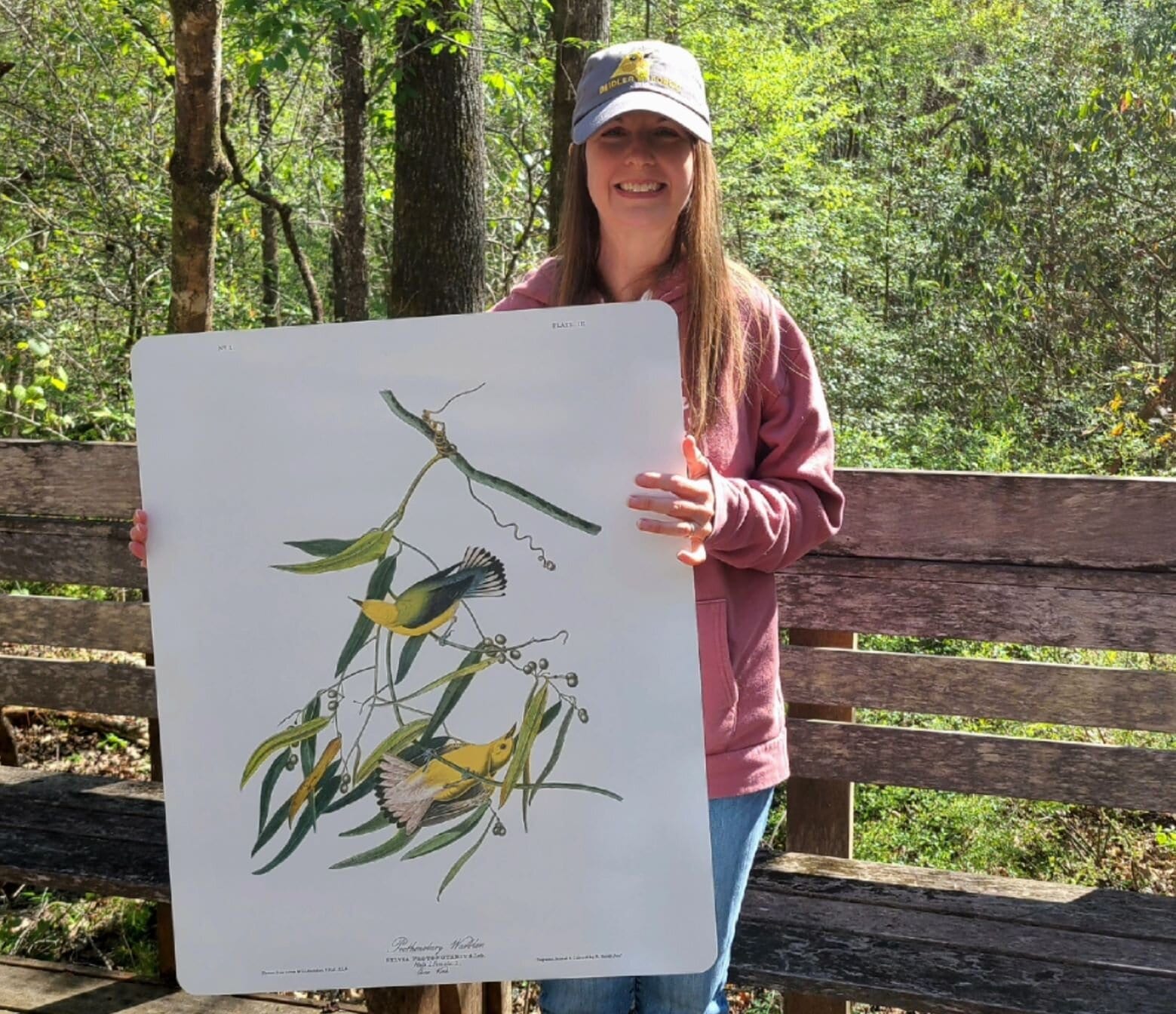 A woman is holding a print of two yellow birds