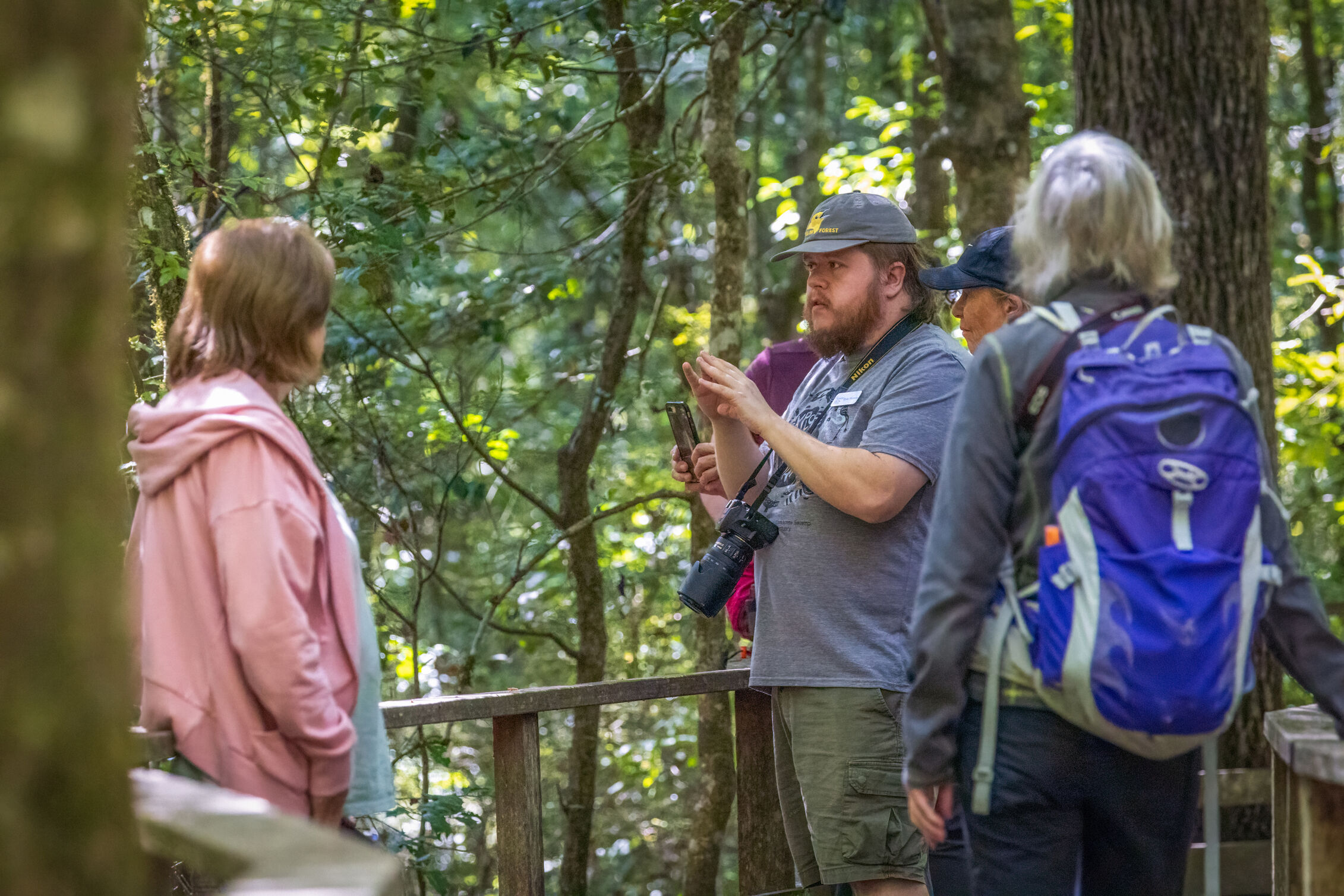 Three people are standing on a boardwalk surveying. 