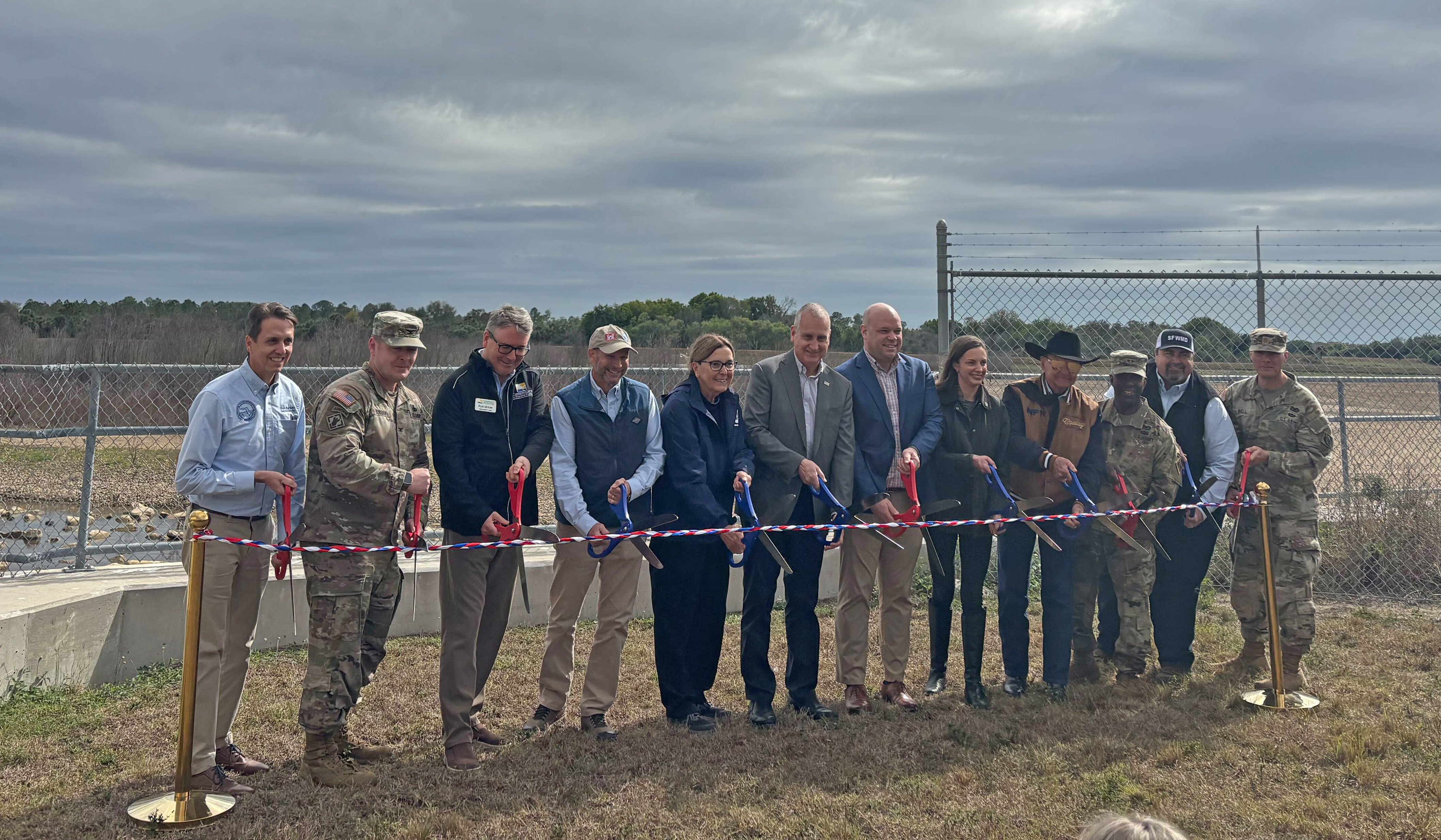 people cutting a big ribbon
