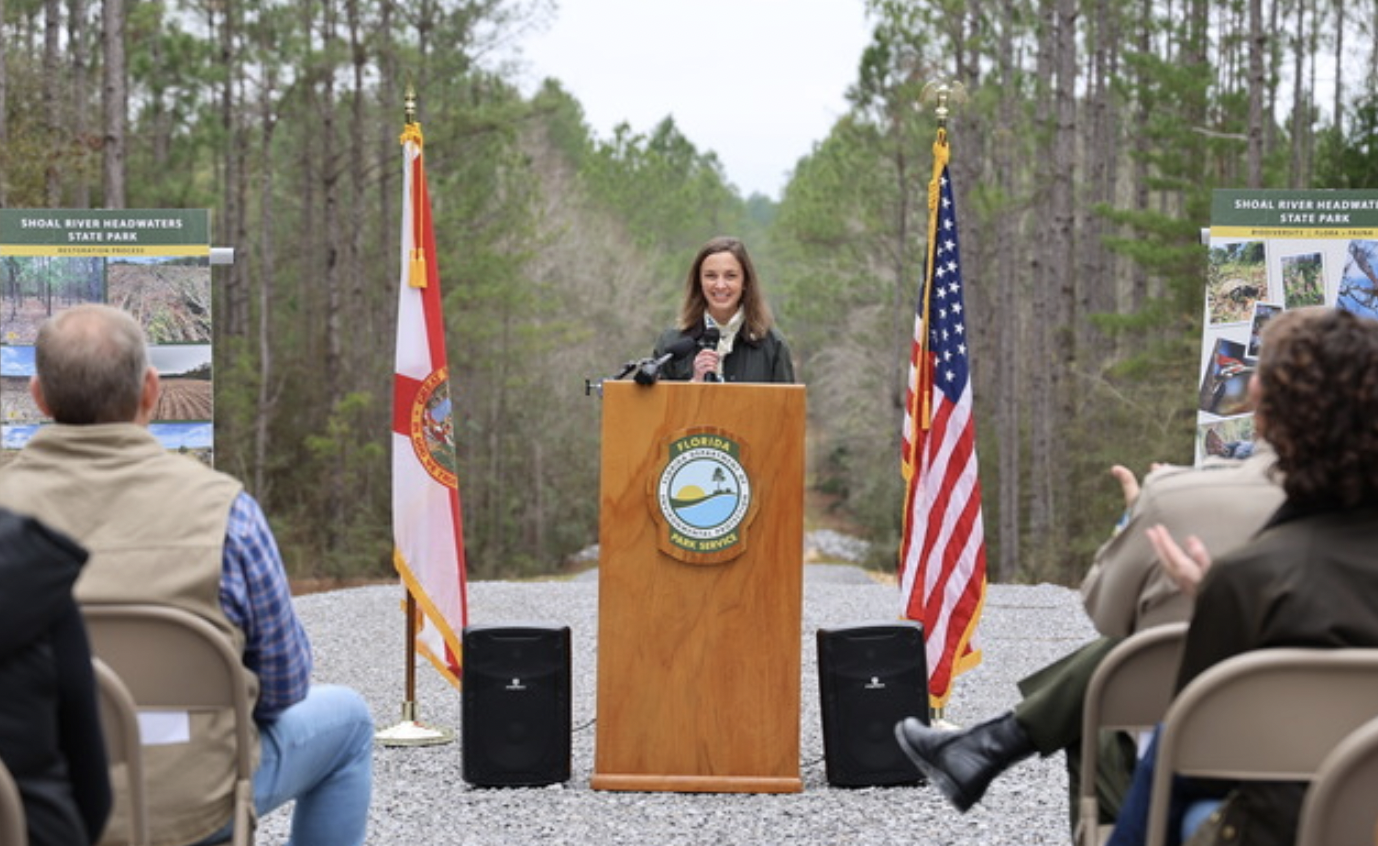 a woman stands at a podium