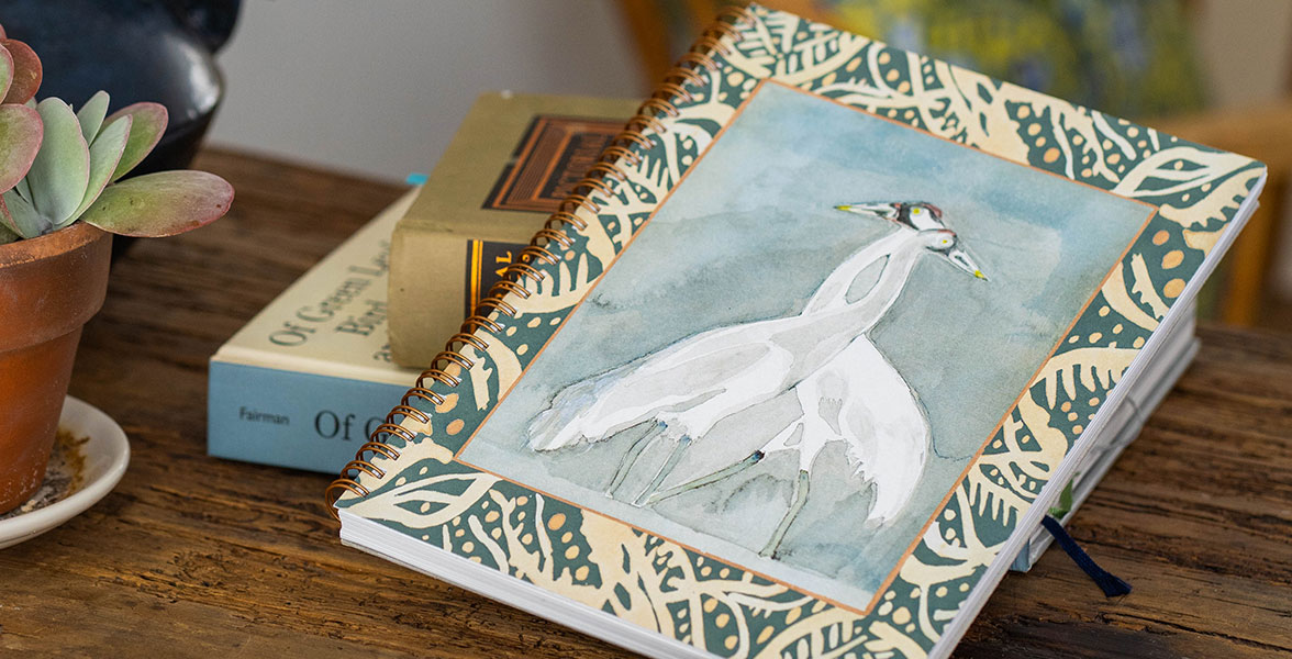 An Isa Catto Studio Collection notebook featuring Whooping Crane art on the front cover.